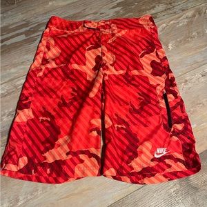 Boys XL Nike swim trunks red camo design. Zipper pocket on front leg, EUC